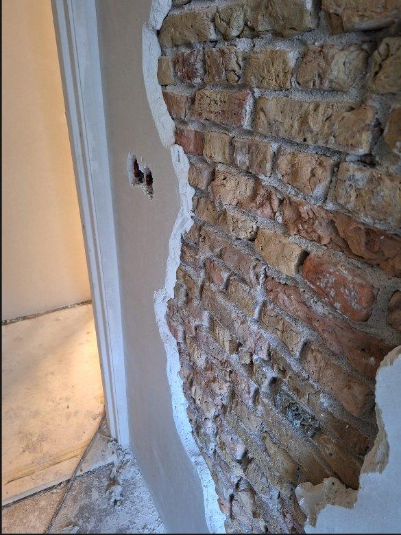 Detail van de overgang tussen het strakke stucwerk en het zichtbare metselwerk