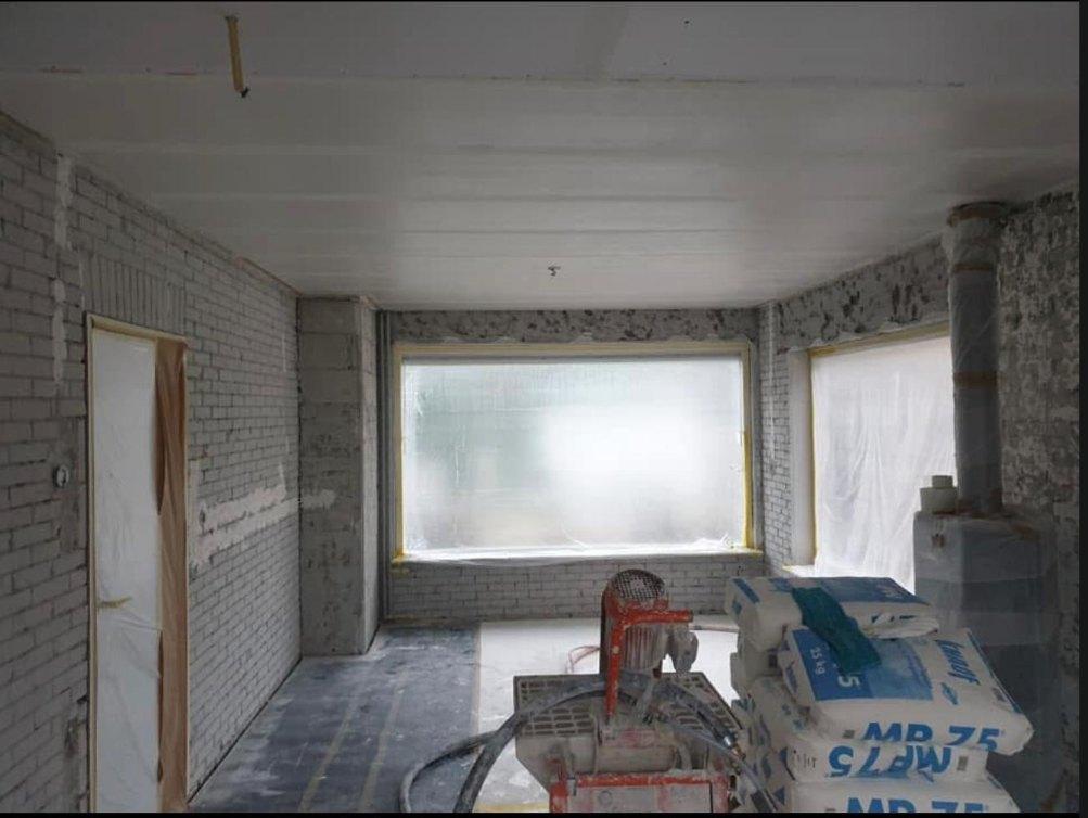 Woonkamer gestript tot op het metselwerk, klaar om machinaal te stucen