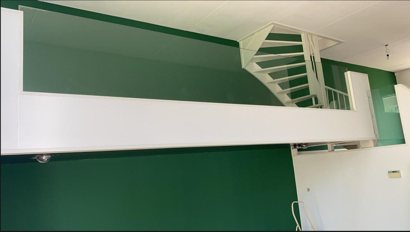 Dezelfde wanden gestuct en in een diepe groene kleur gespoten, van vloer tot bovenverdieping