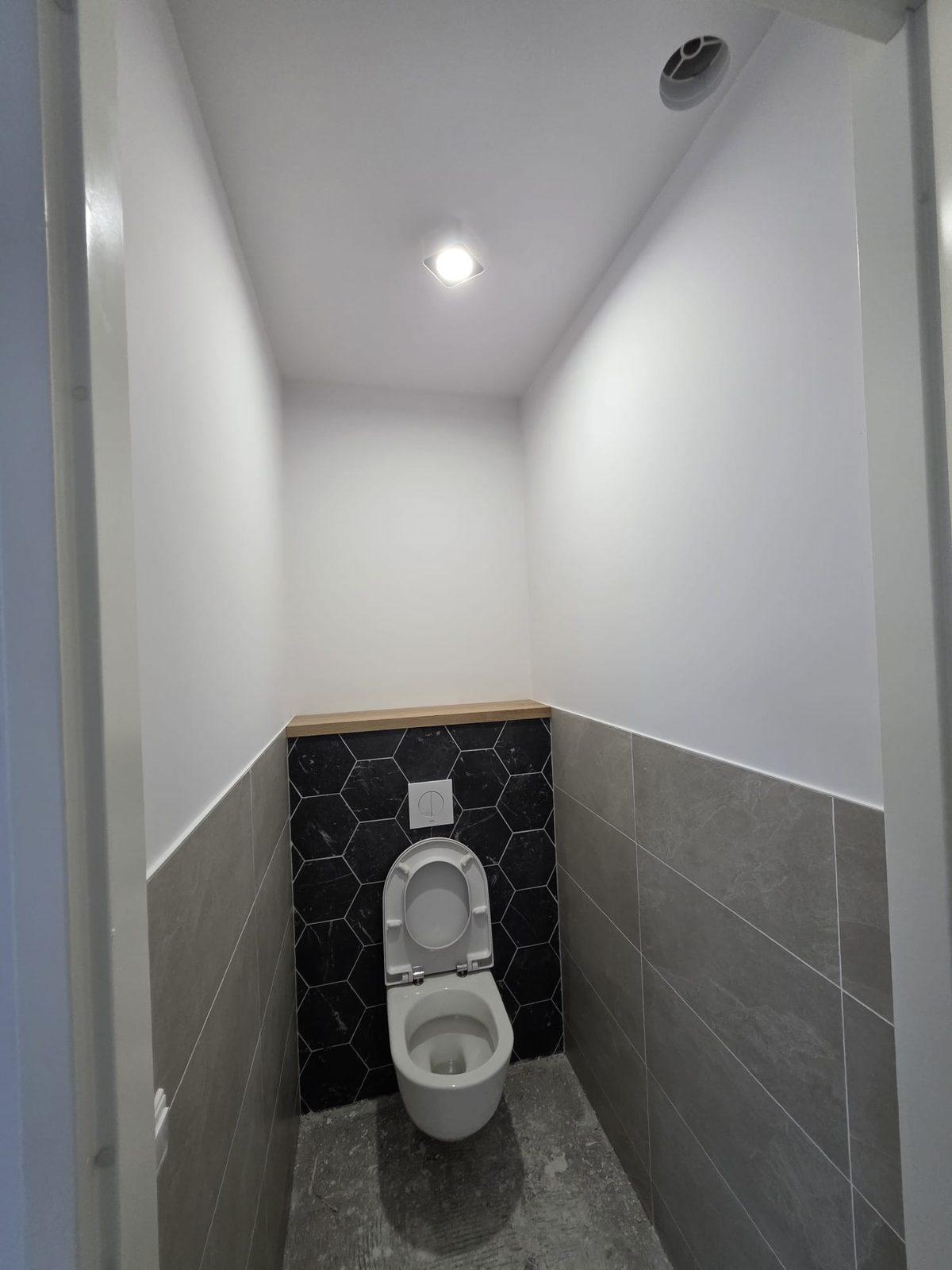 Egaal gespoten wanden en plafond in een toilet