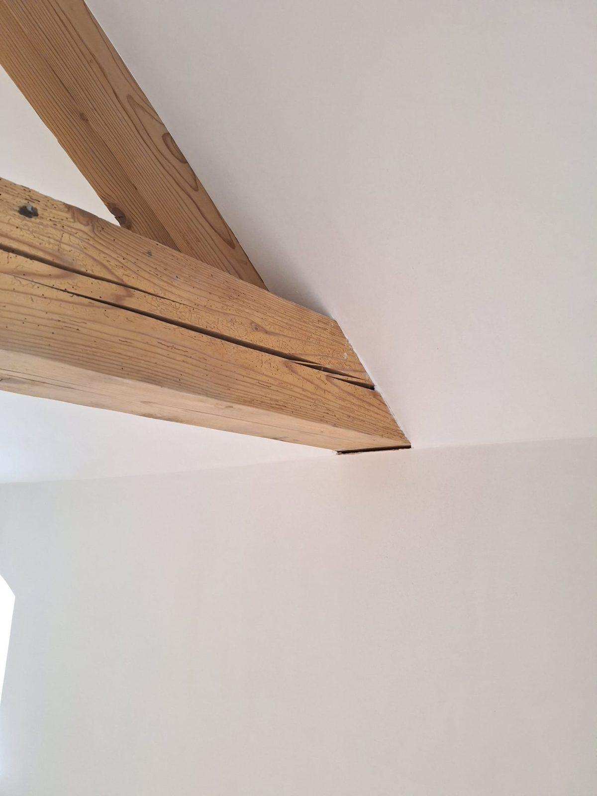 Strak gestuct plafond rond oude houten balken