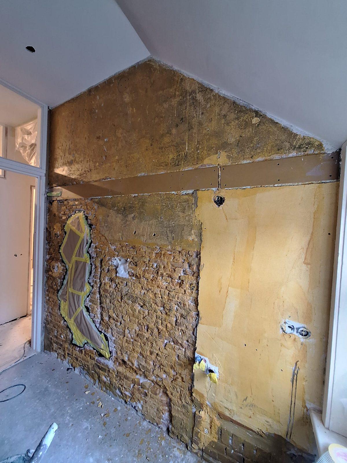 Oude wand met kaal metselwerk voor het stucen